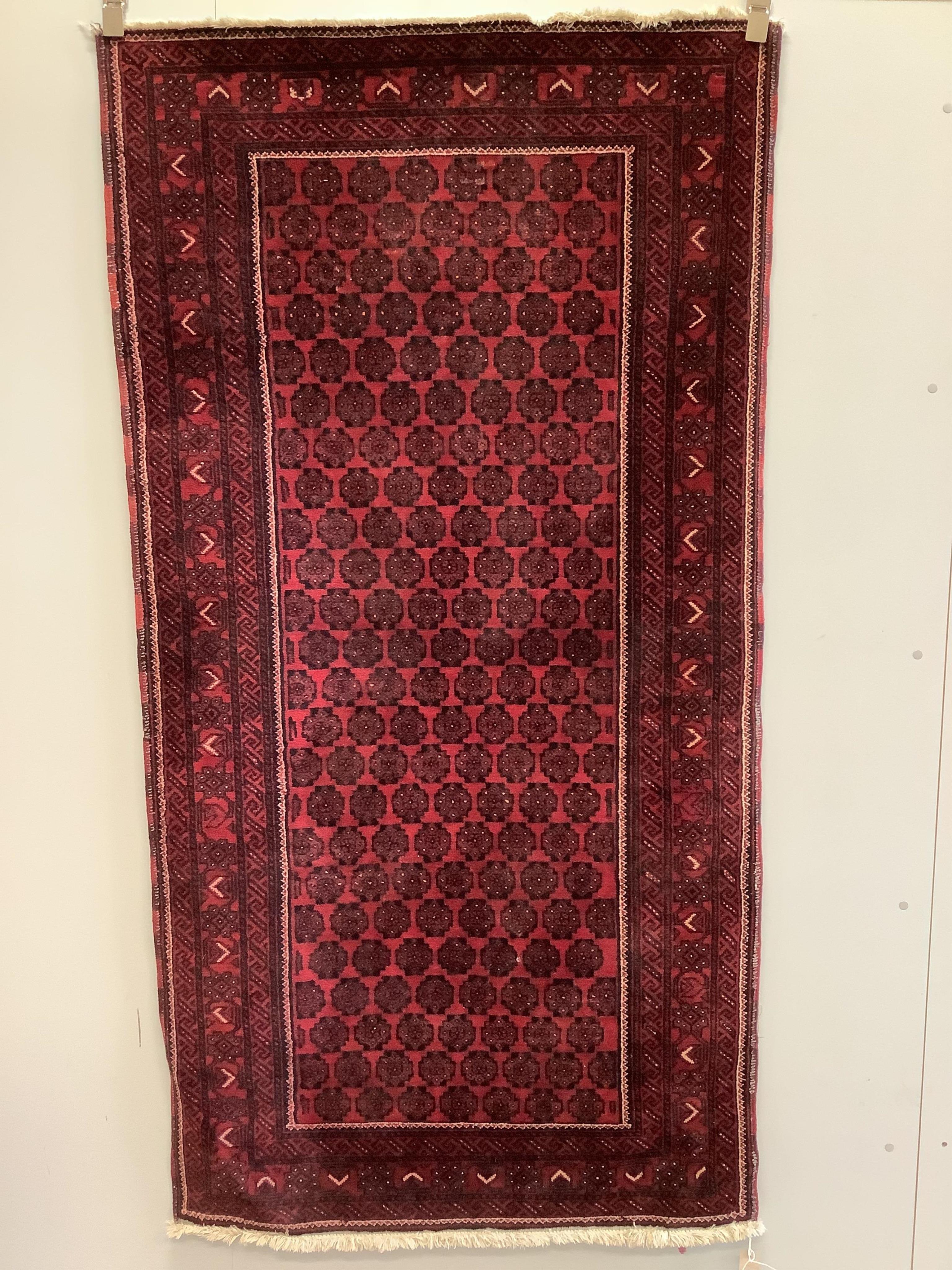 A Belouch red ground rug, 200 x 103cm. Condition - fair